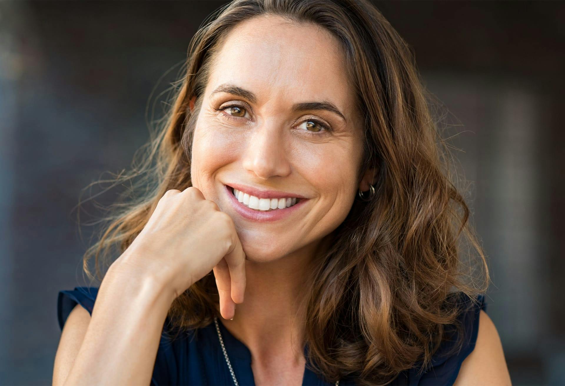 woman smiling resting head on fist