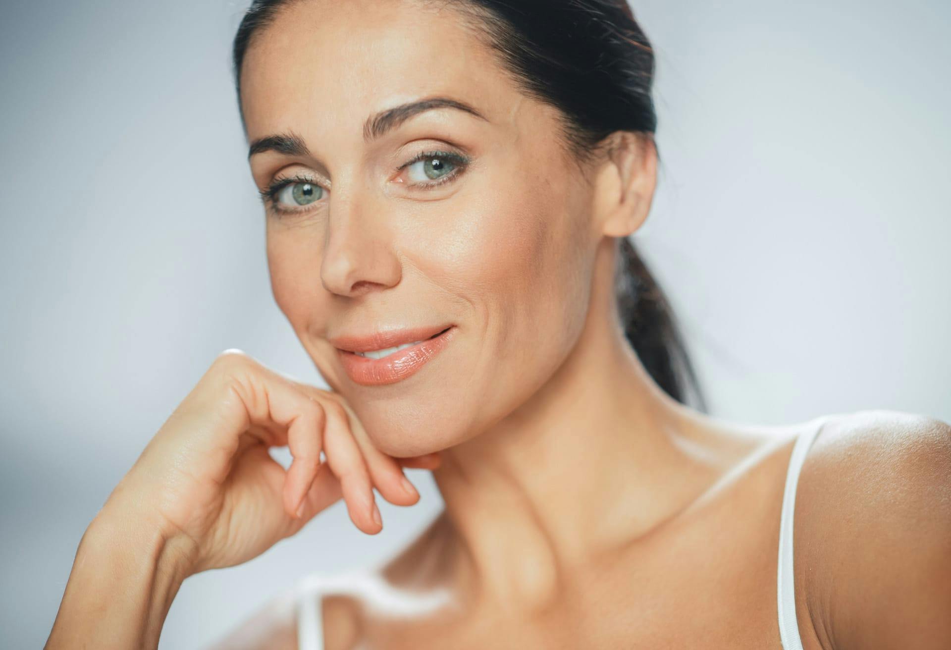 woman smiling and resting chin on hand