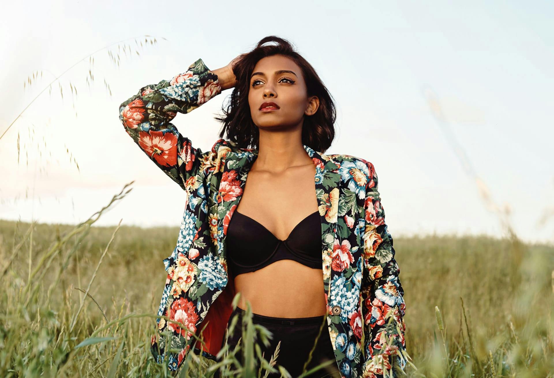 Model standing out in tall grass field