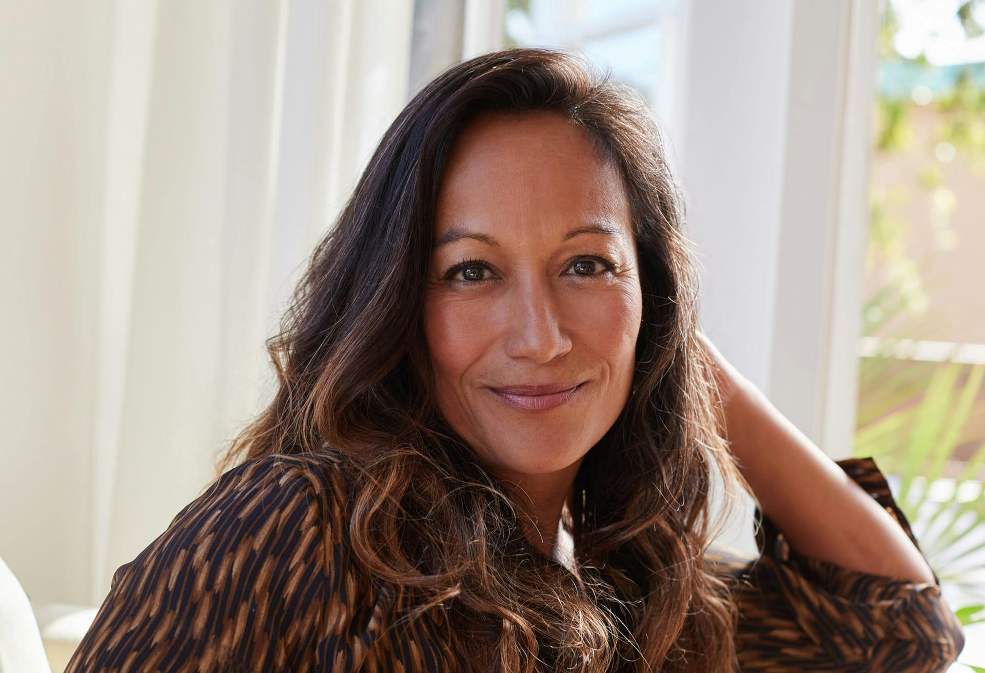 woman smiling and leaning on couch