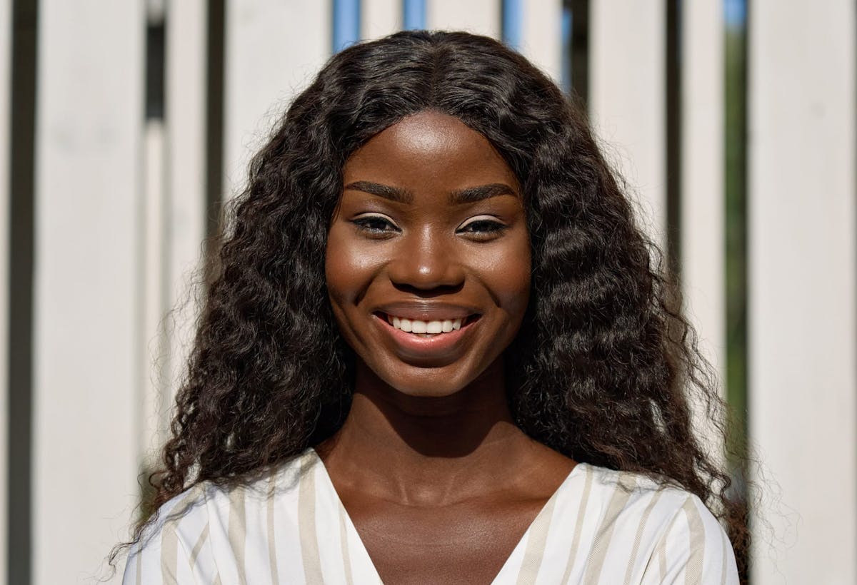 woman smiling and standing in front of fence