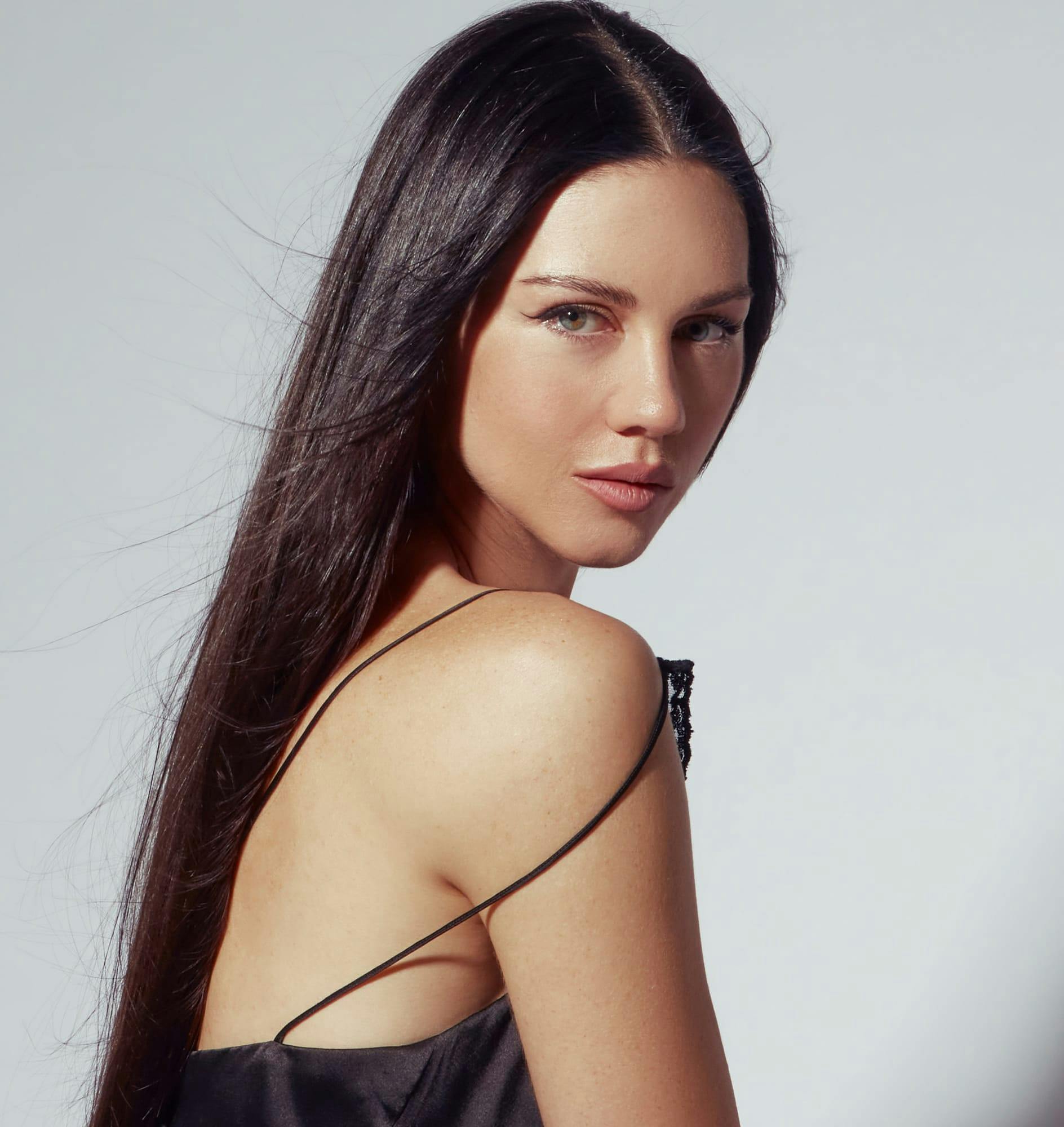 Woman with dark hair looking over her shoulder
