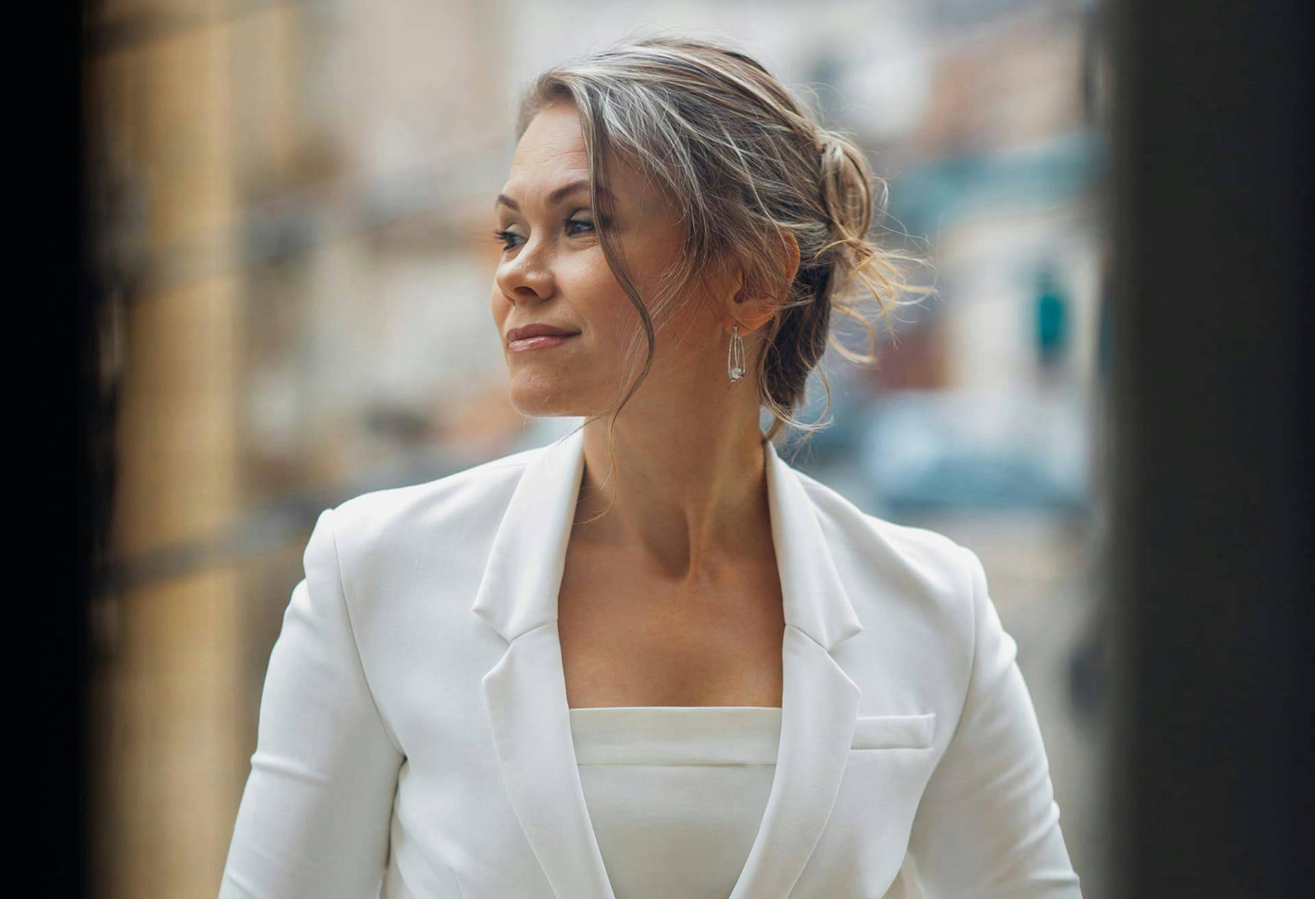 Woman smiling in business clothes looking to her right