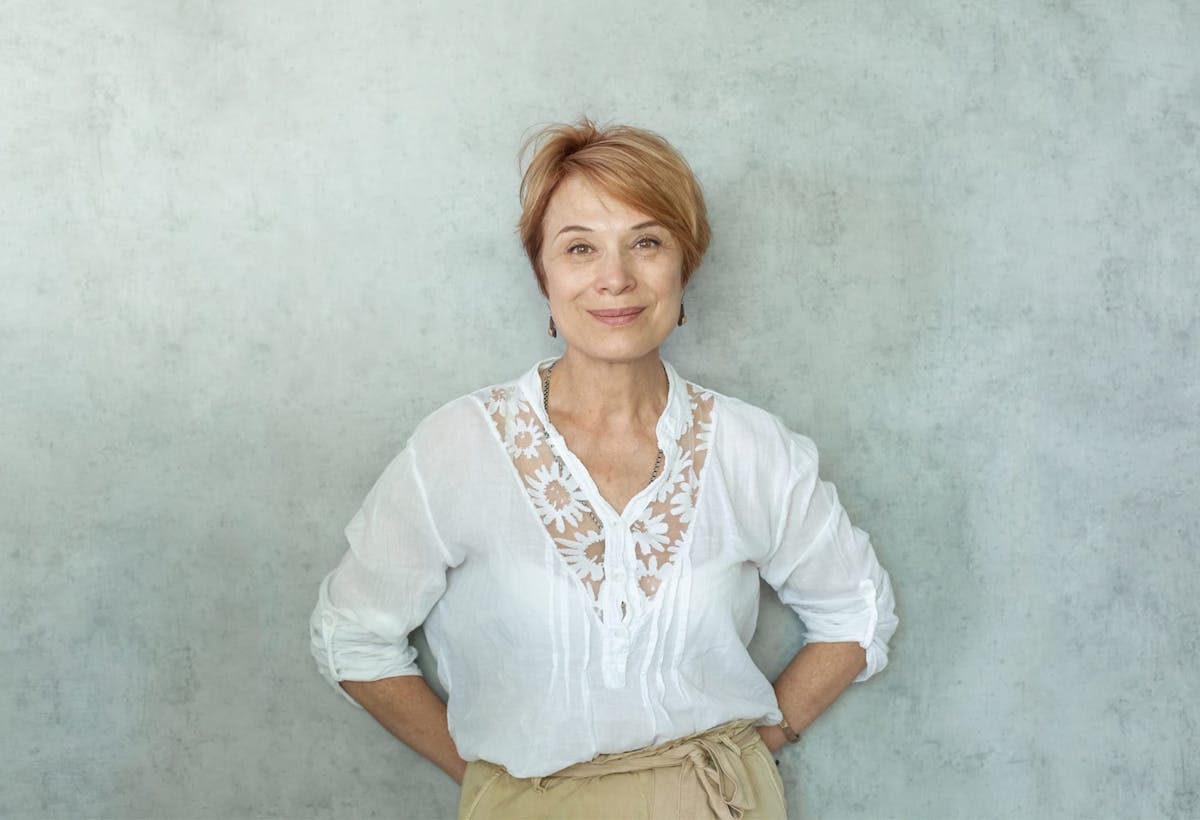 smiling older woman with hand on her hips