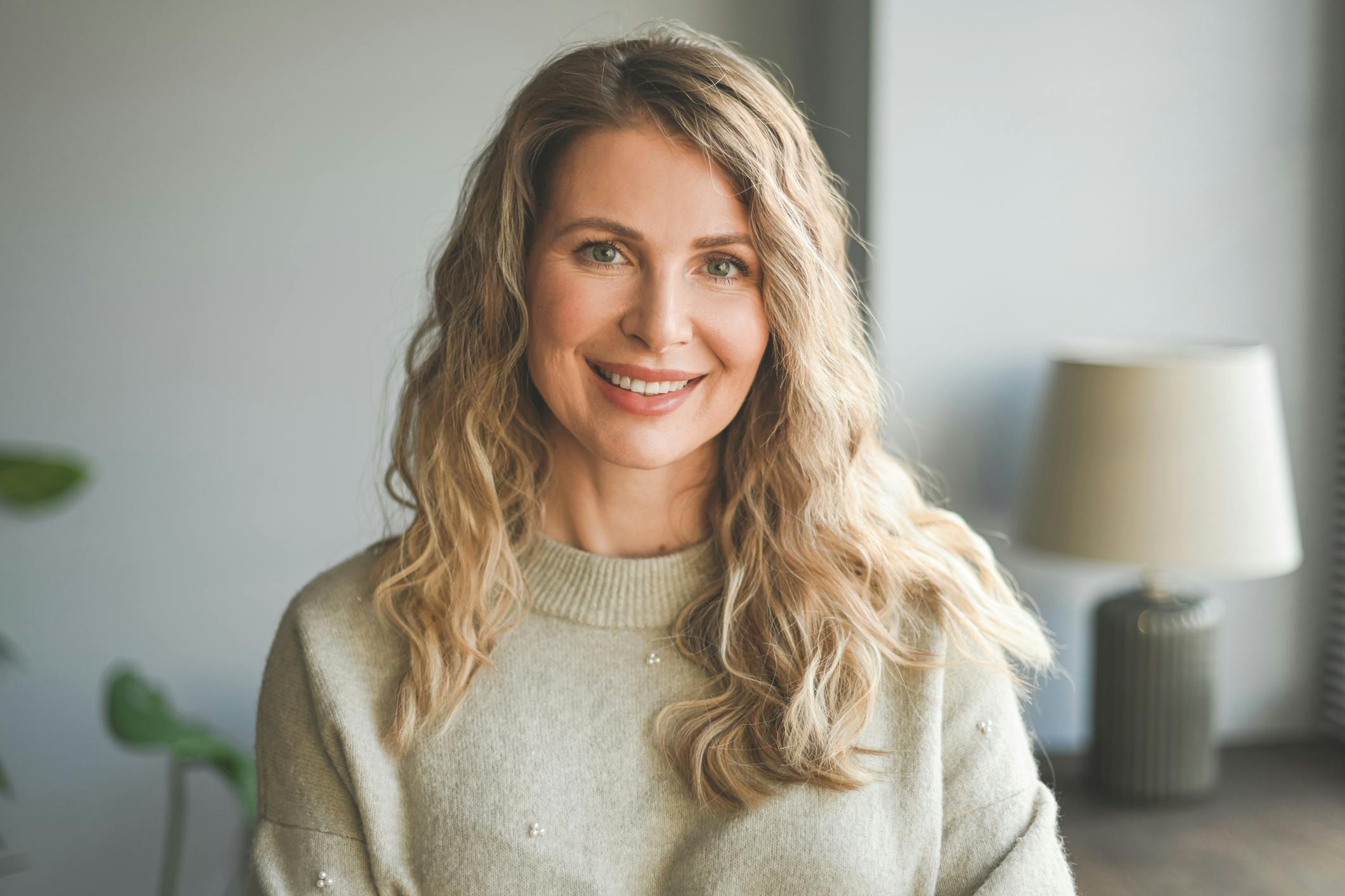 Woman smiling and sitting in front of lamp