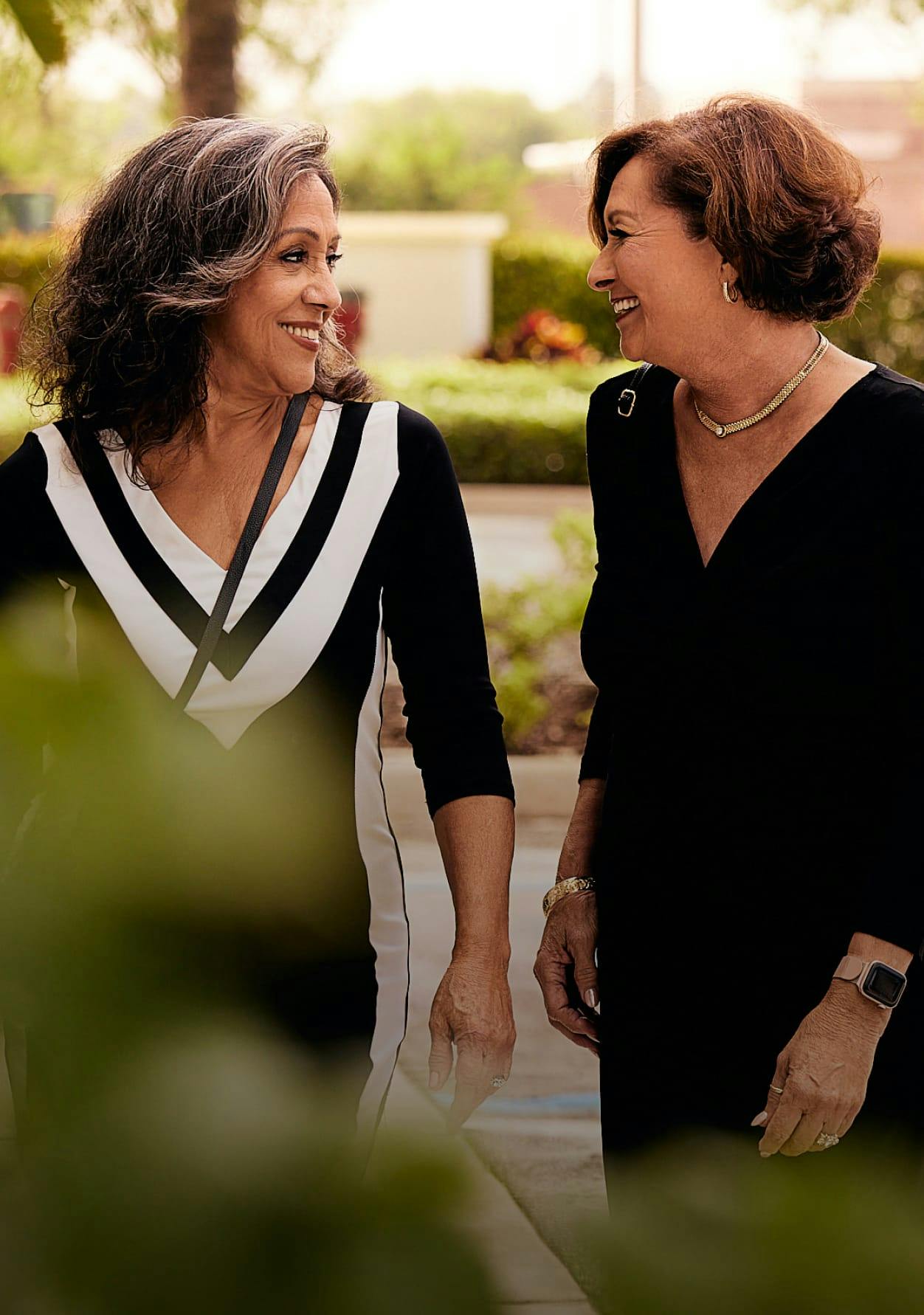 Two women smiling at one another.