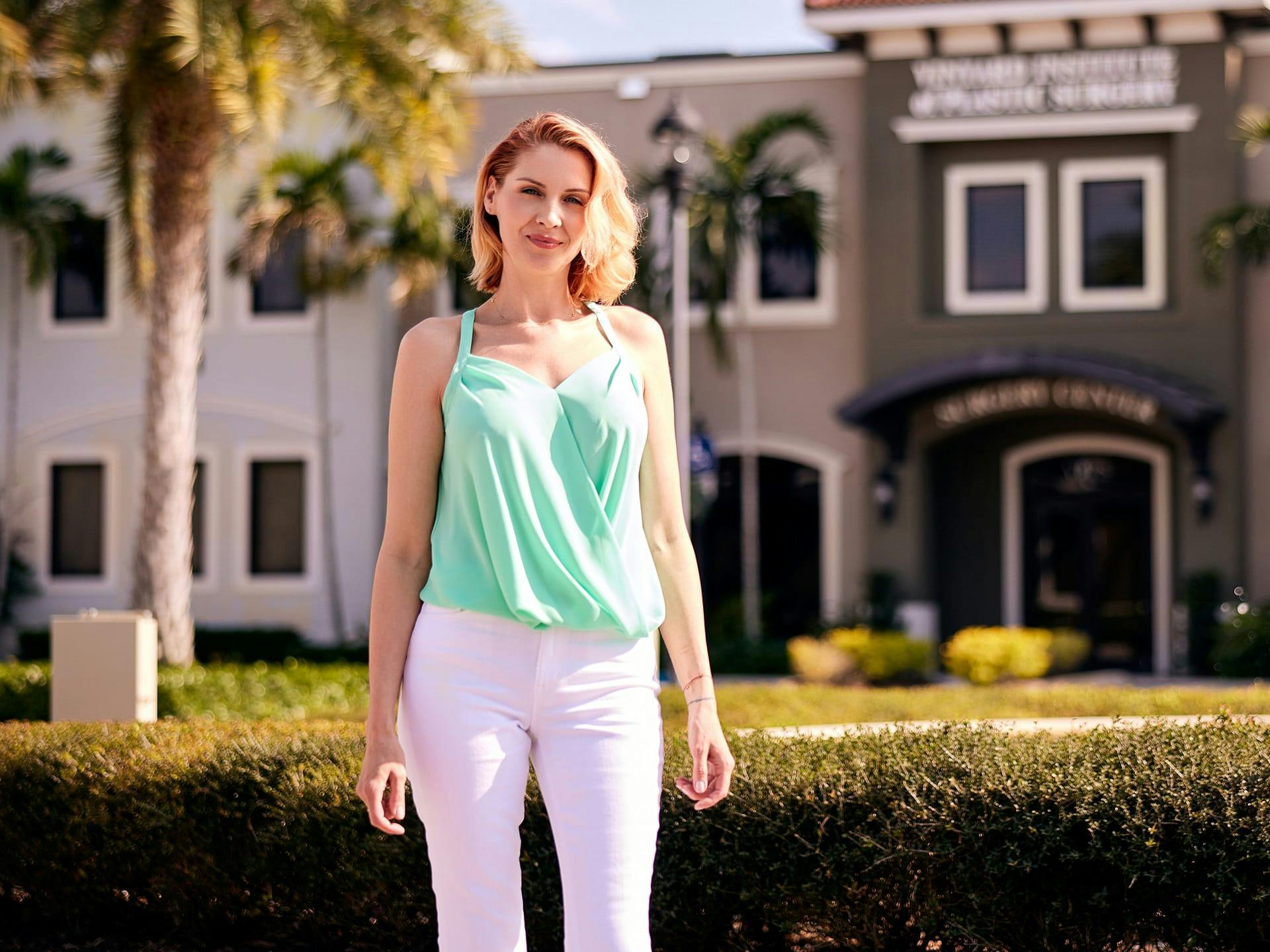 Woman wearing mint green top and white pants