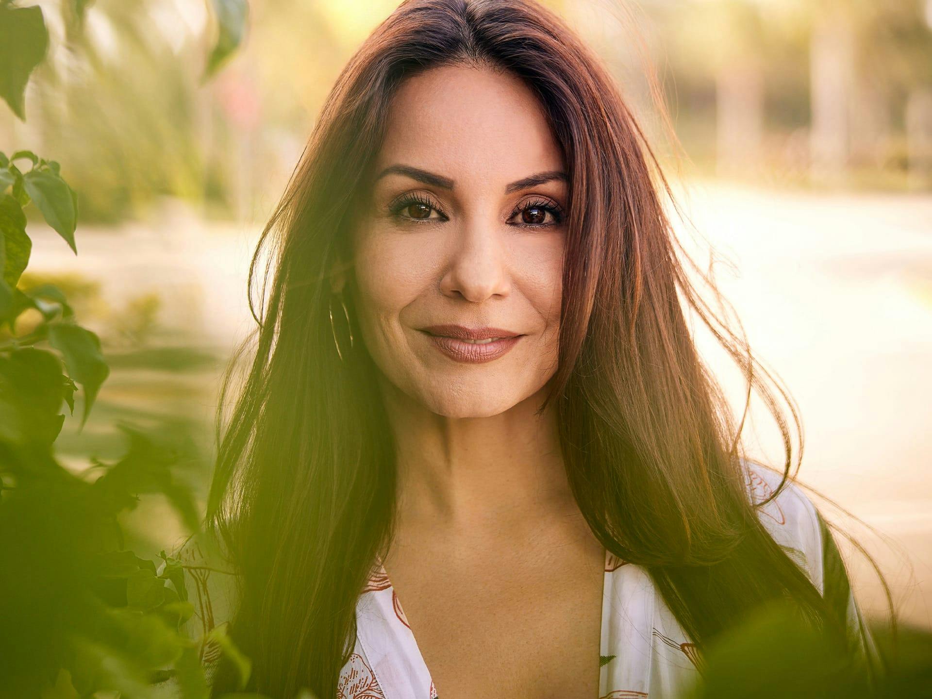 Brunette woman standing outside smiling