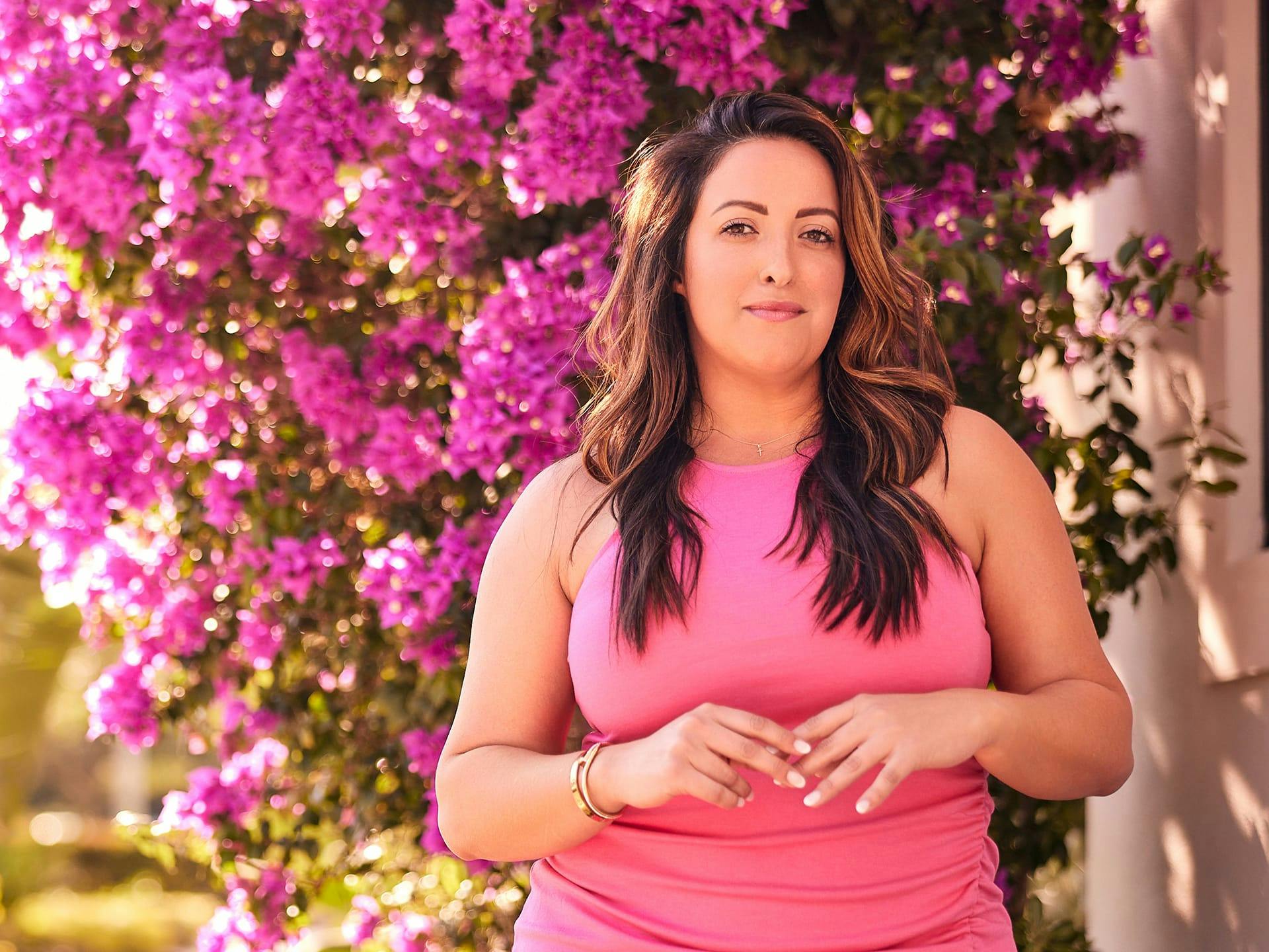 Woman standing in front pink flowers