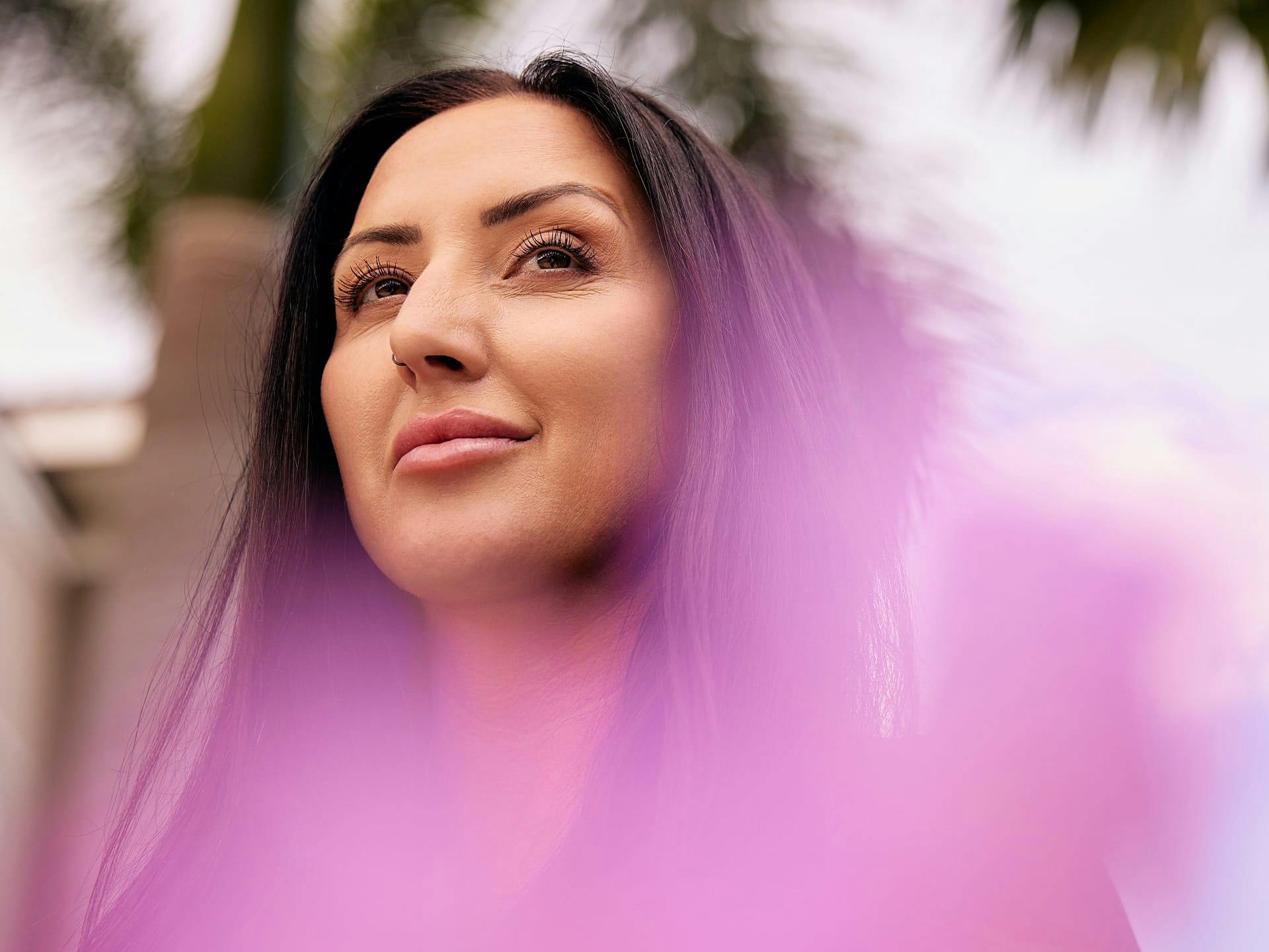 Woman with dark hair standing outside