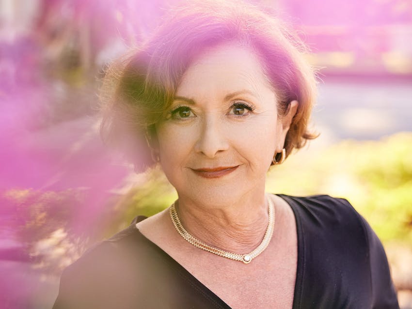 Woman wearing a black top and gold jewelry