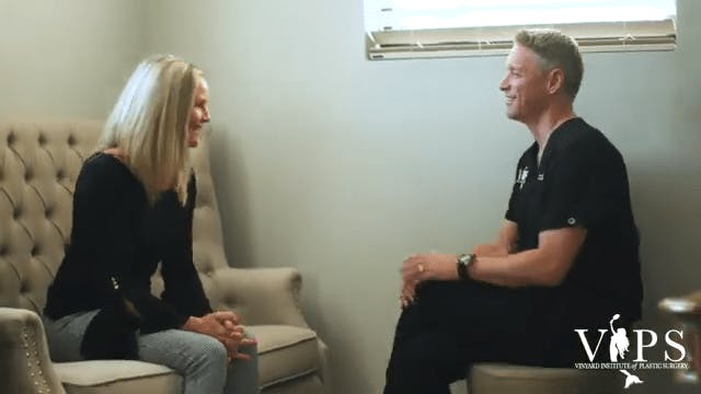 Dr. Vinyard speaking to a woman on a couch.