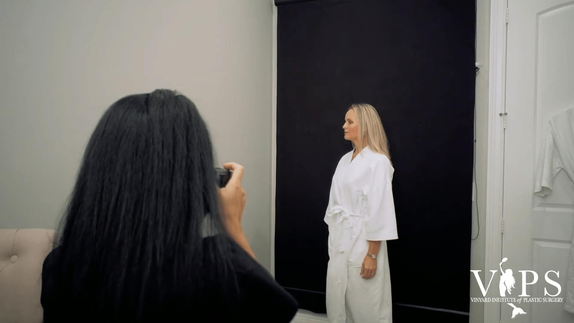 Woman in a white robe getting her picture taken.