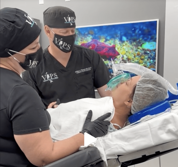 Dr. Vinyard in scrubs looking down at a patient