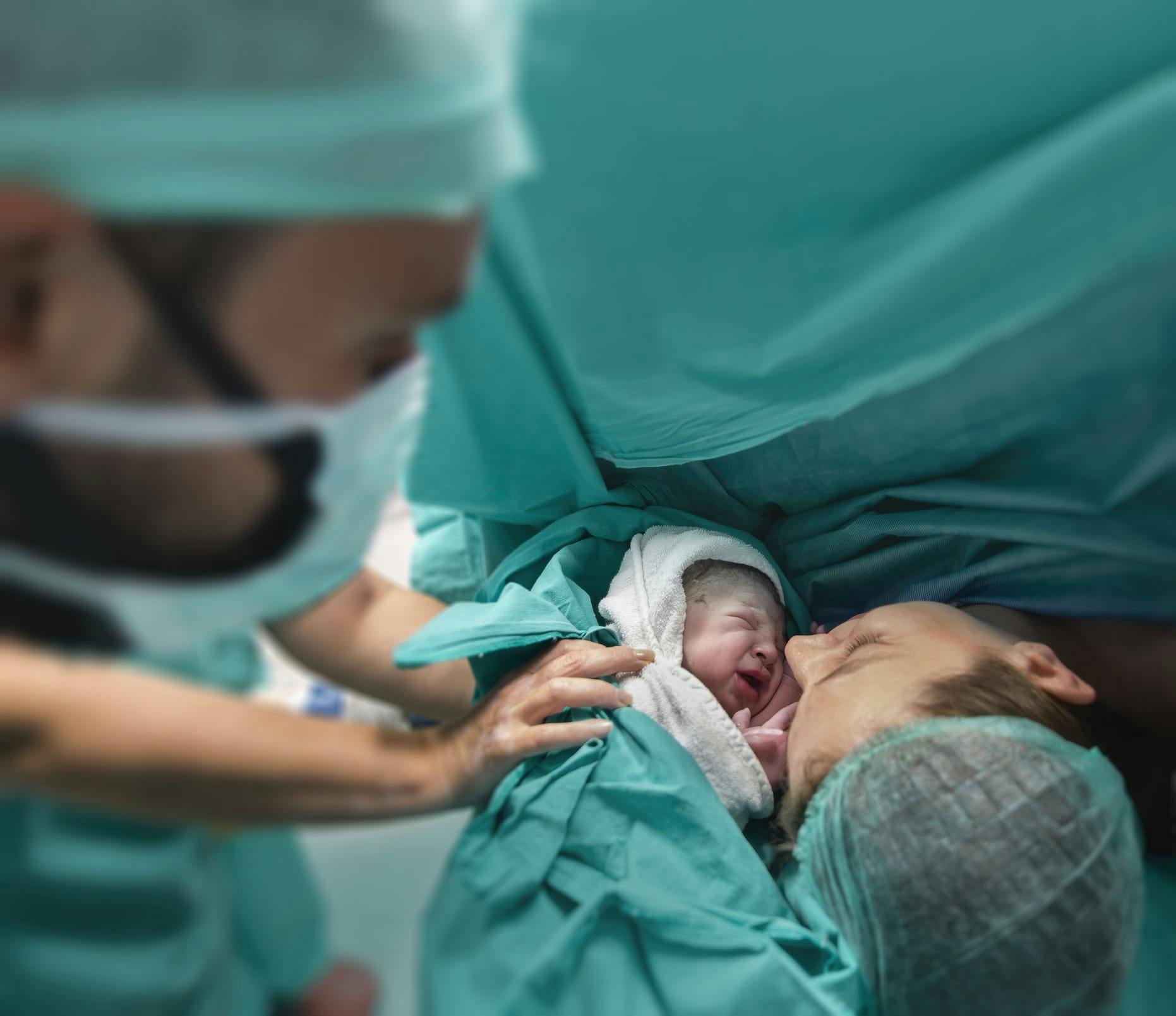 woman meeting her baby for the first time during a c-section