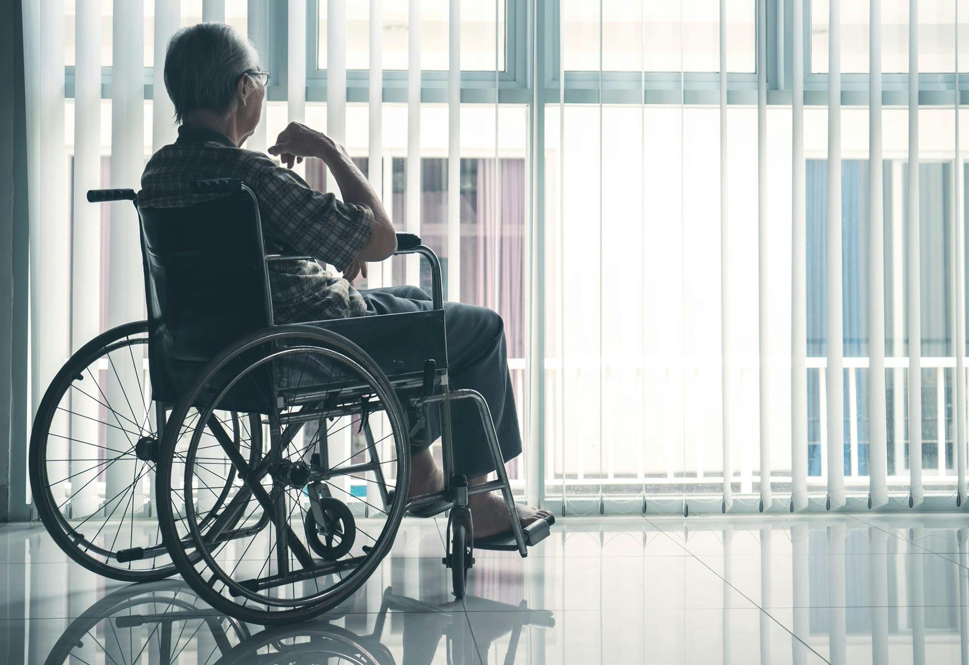 elderly person in wheelechair looking out window