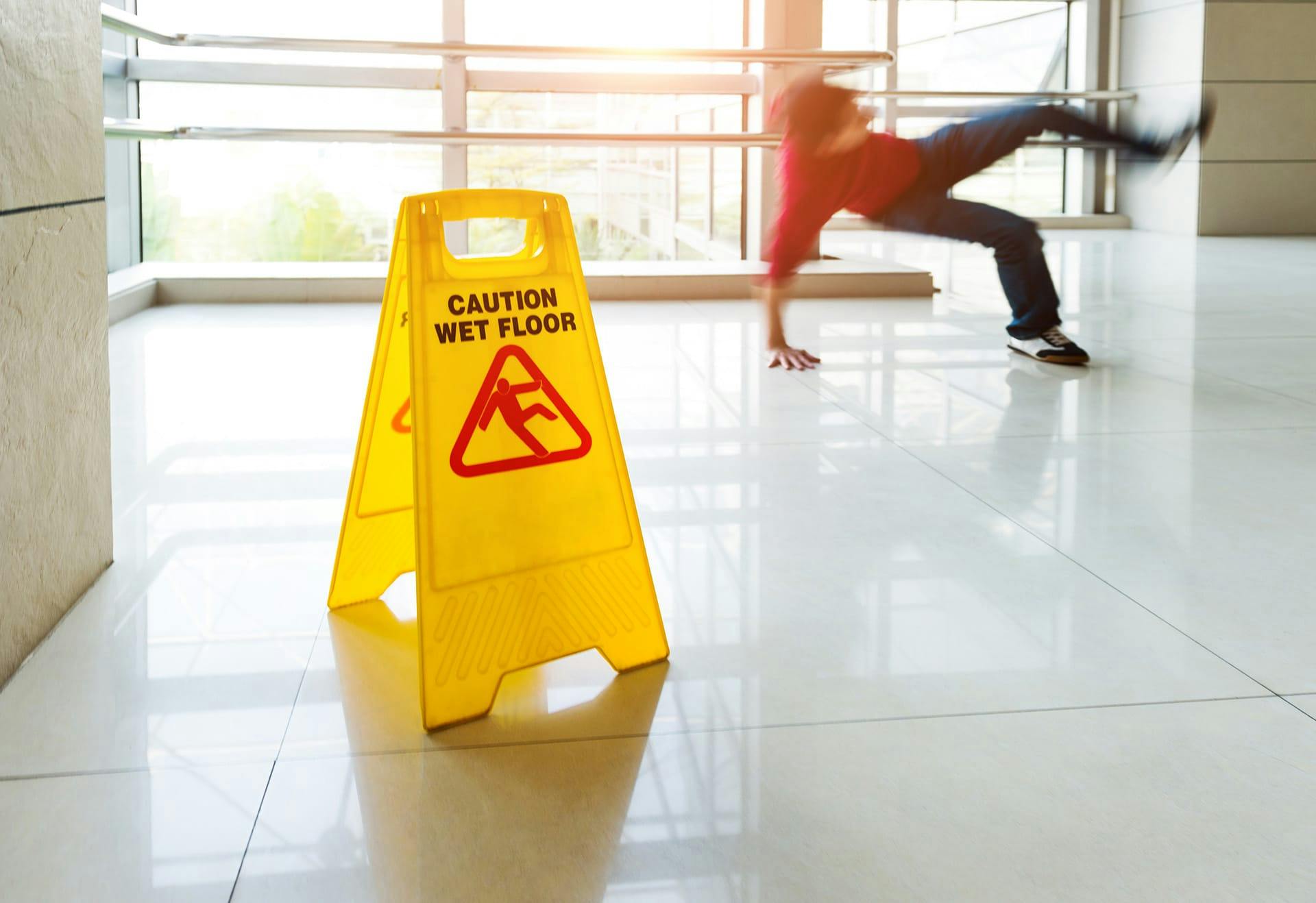 a wet floor sign and person slipping