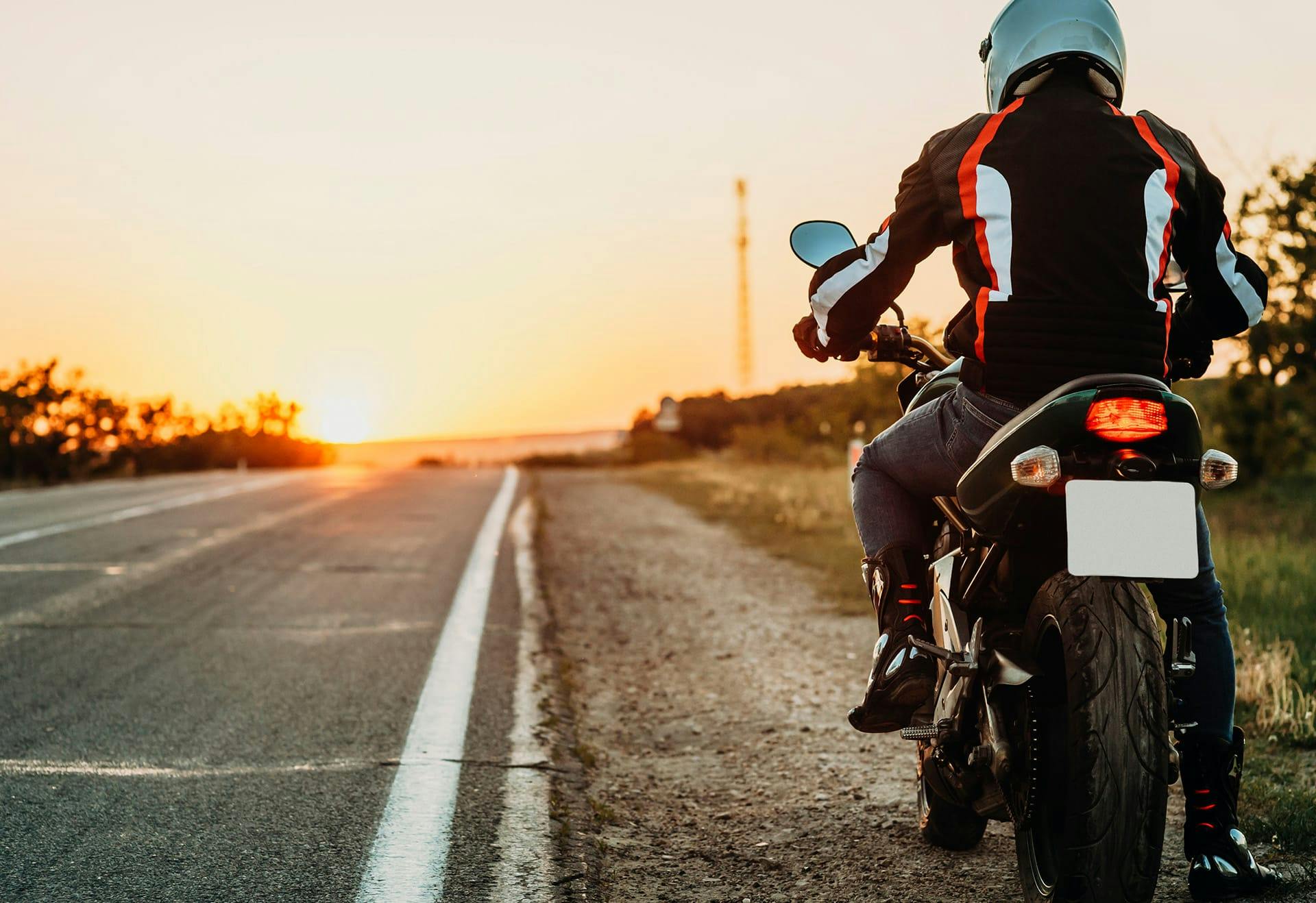 man riding motorcycle down road