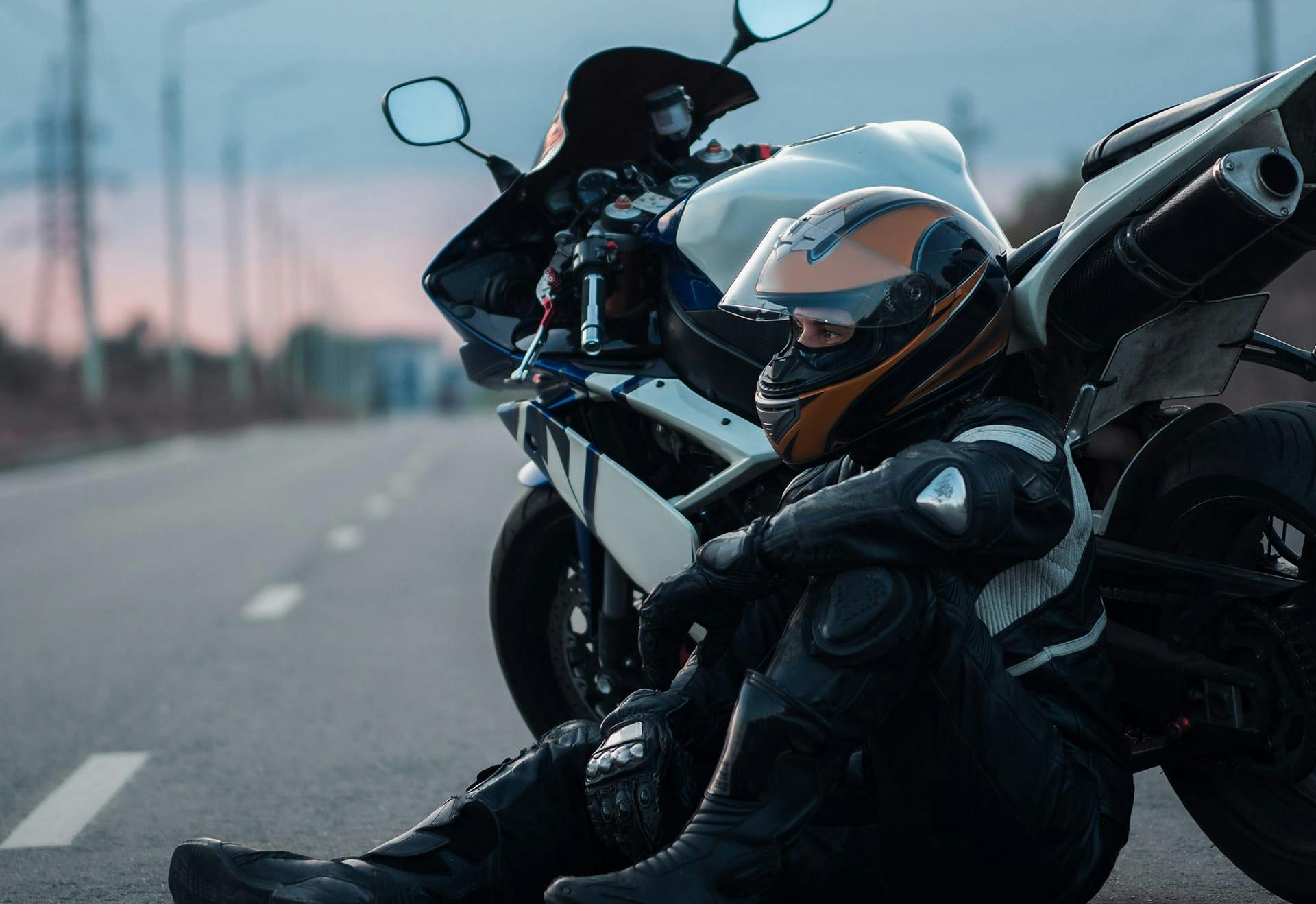 man sitting against motorcycle