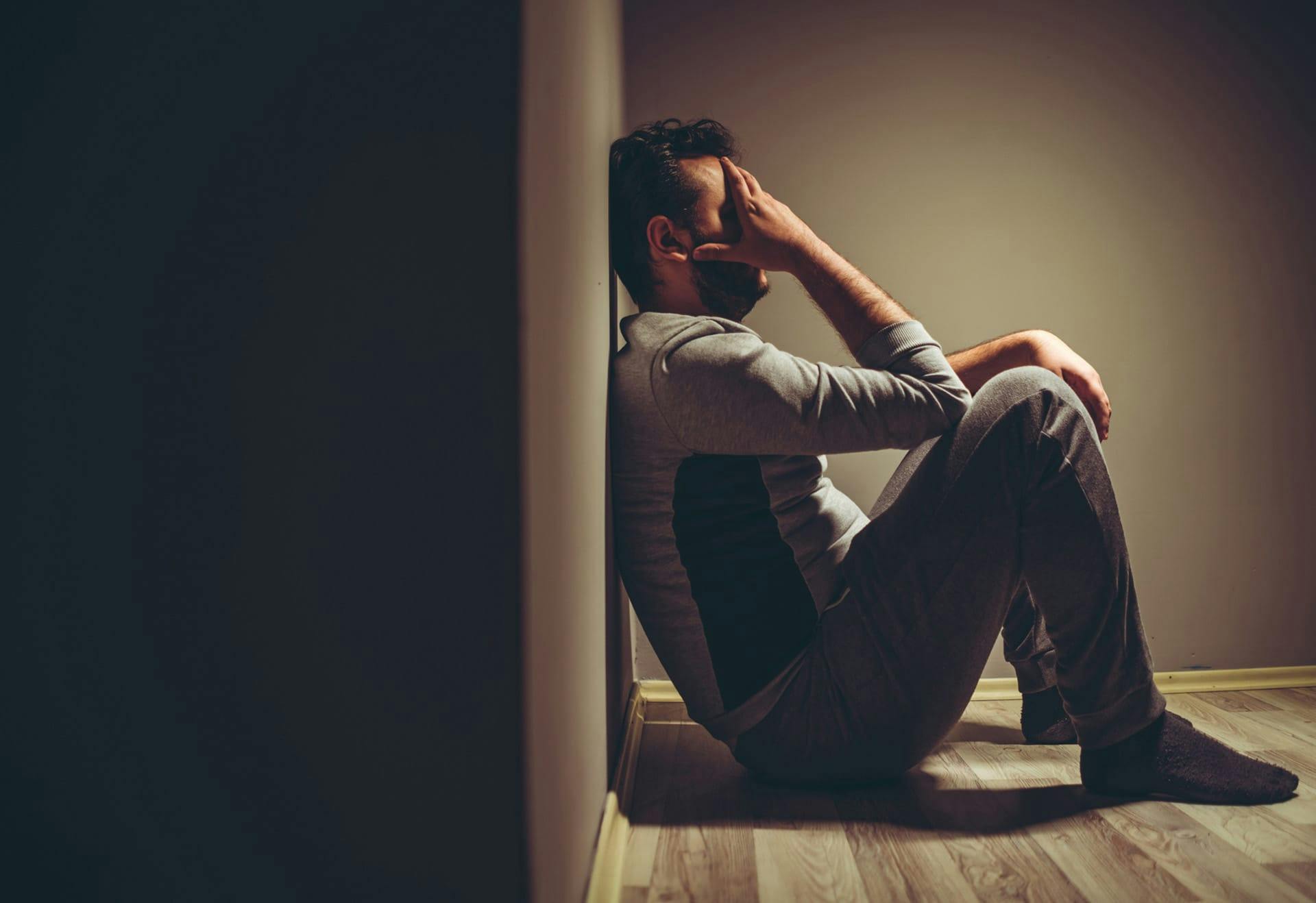 man sitting down looking distraught