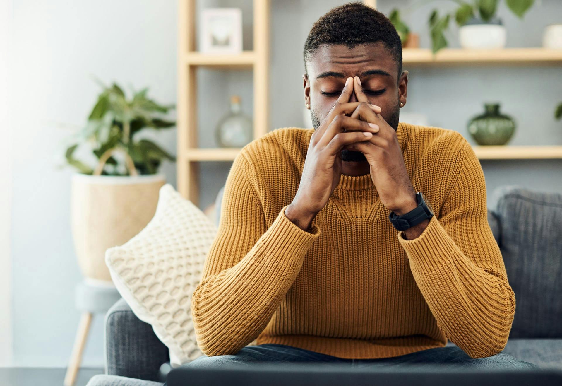 distraught man sitting on couch