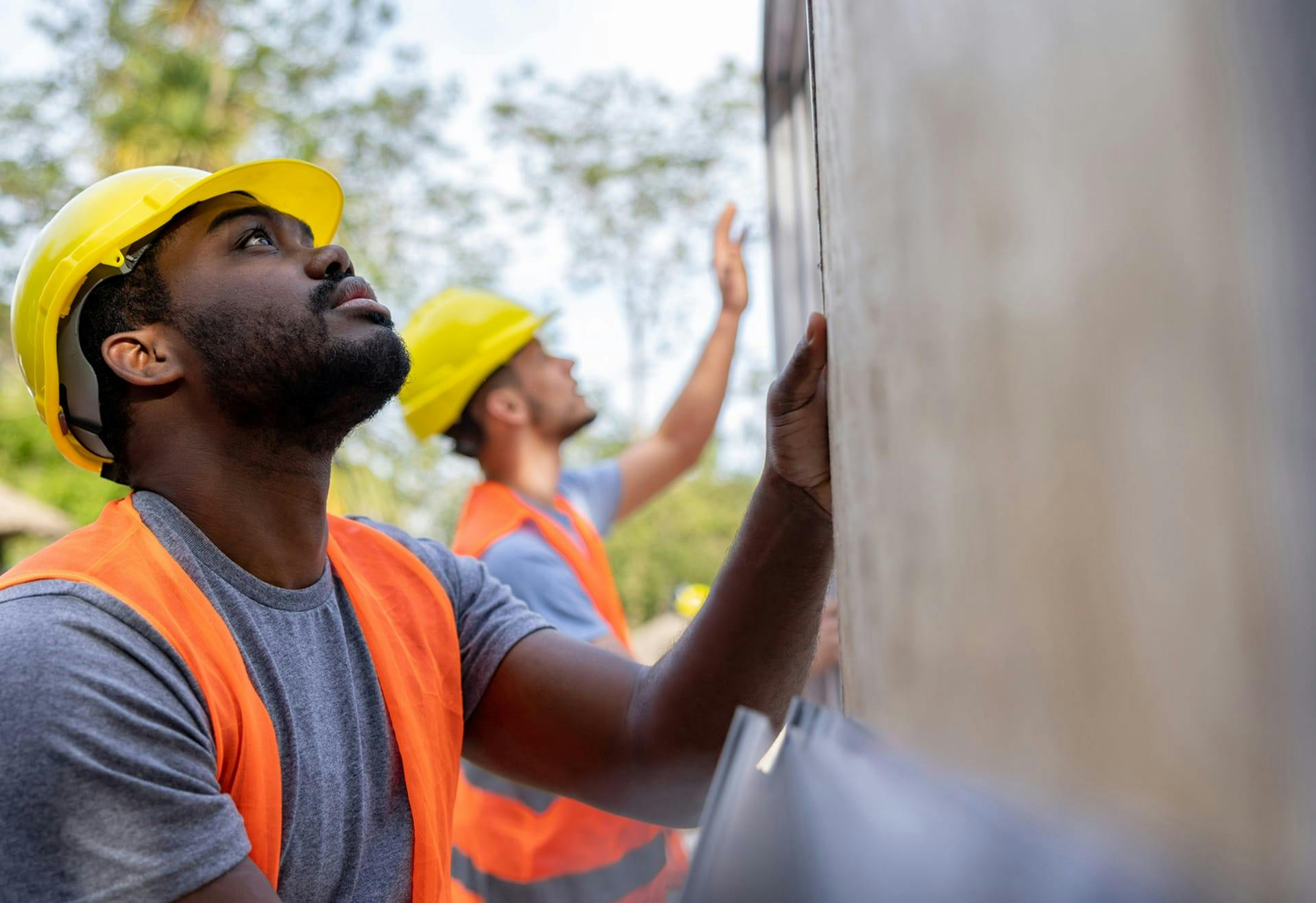 two construction workers working on a wall