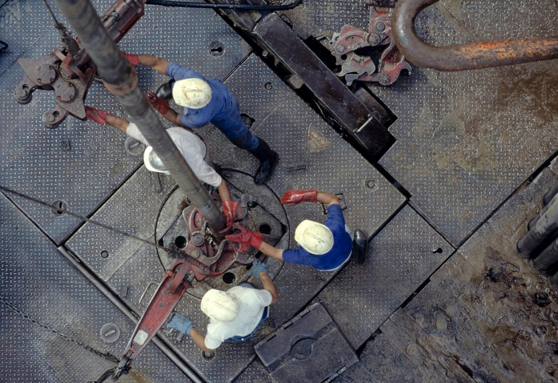 four workers working on oil drill
