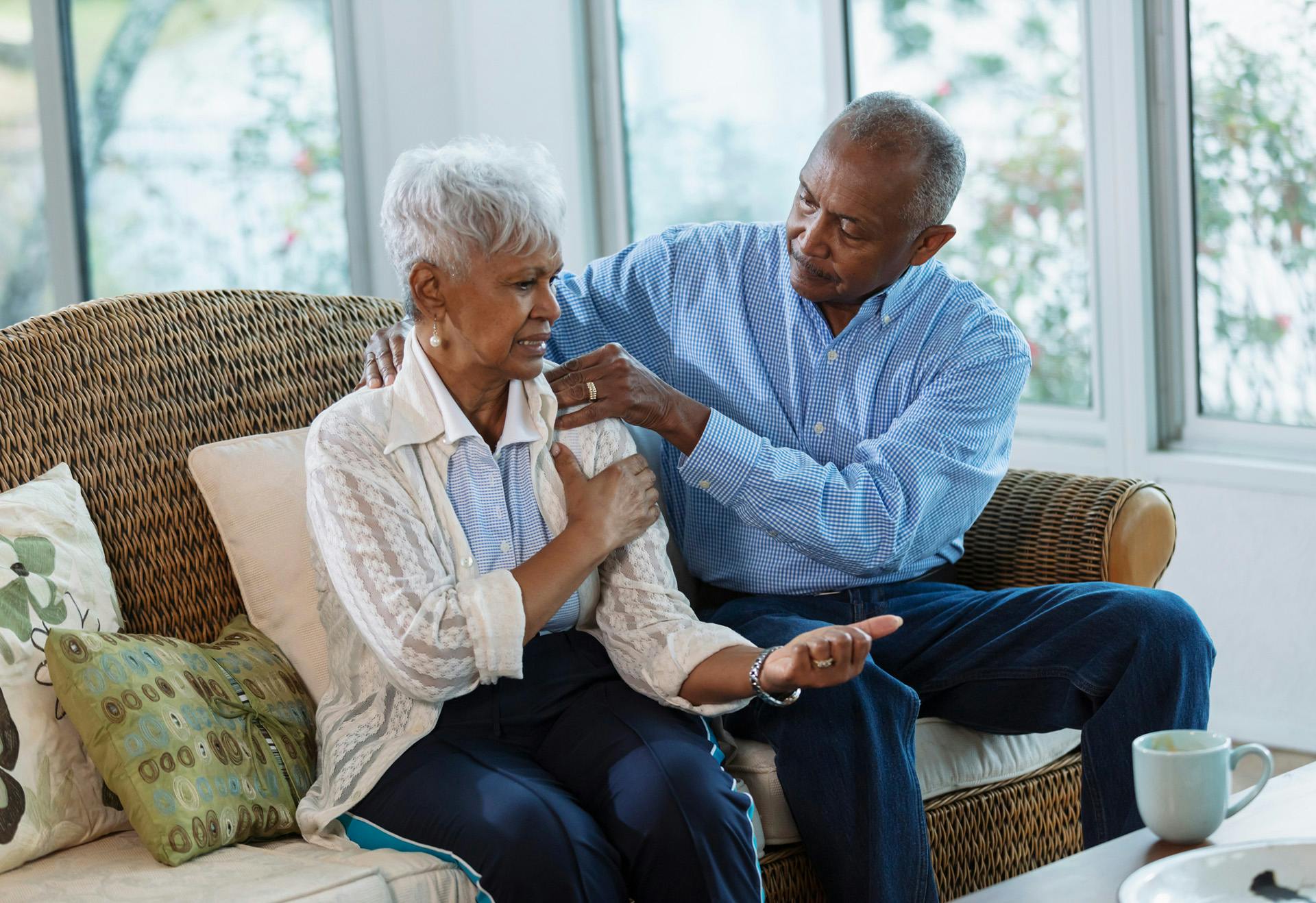Man helping woman with her arm.