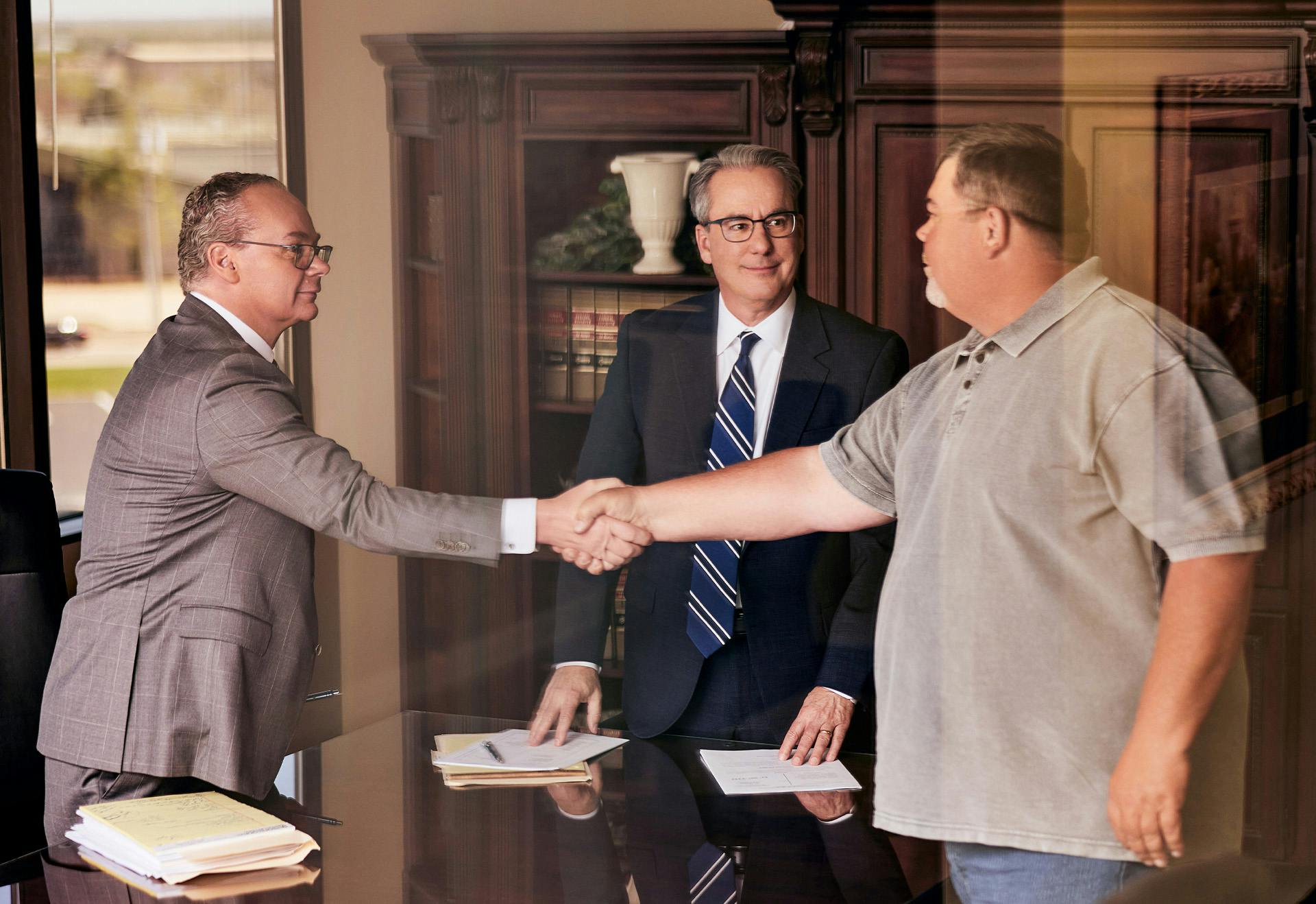 Attorneys Stipe & Belote shaking the hand of a client.