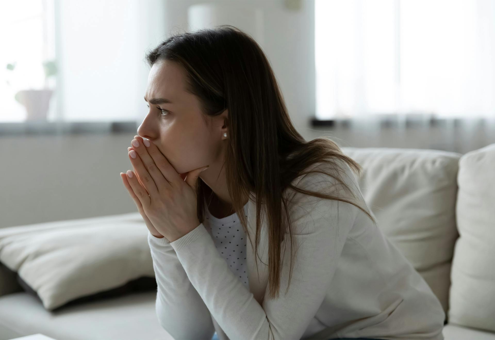 Worried woman sitting on couch