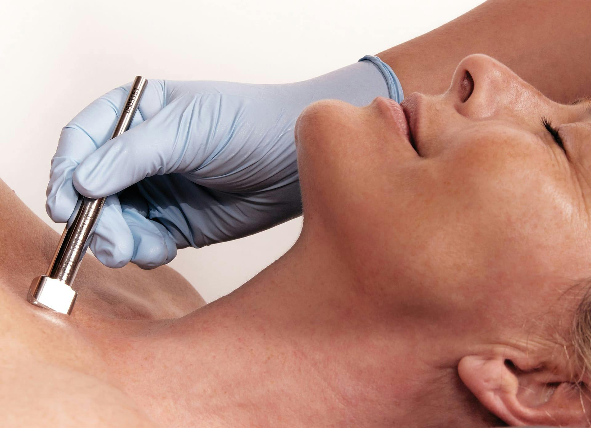 there is a woman receiving DiamondTouch skin treatment from a doctor