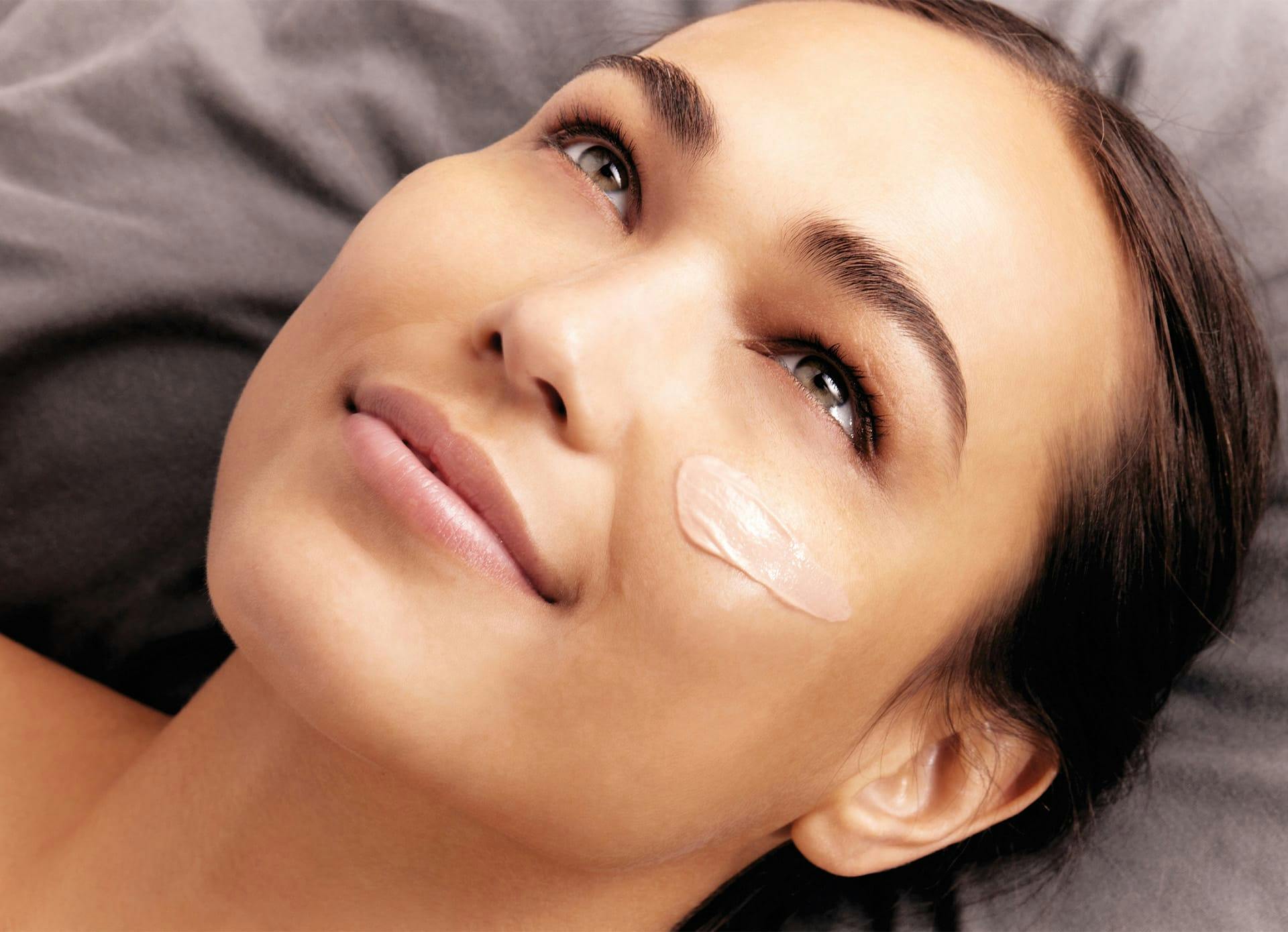 Woman with Skin Product on Cheek - Our Products Banner