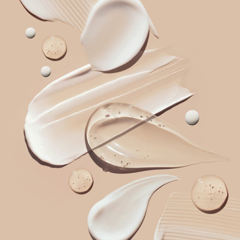 there are smears of different kinds of cosmetic creams spread out on a tan floor