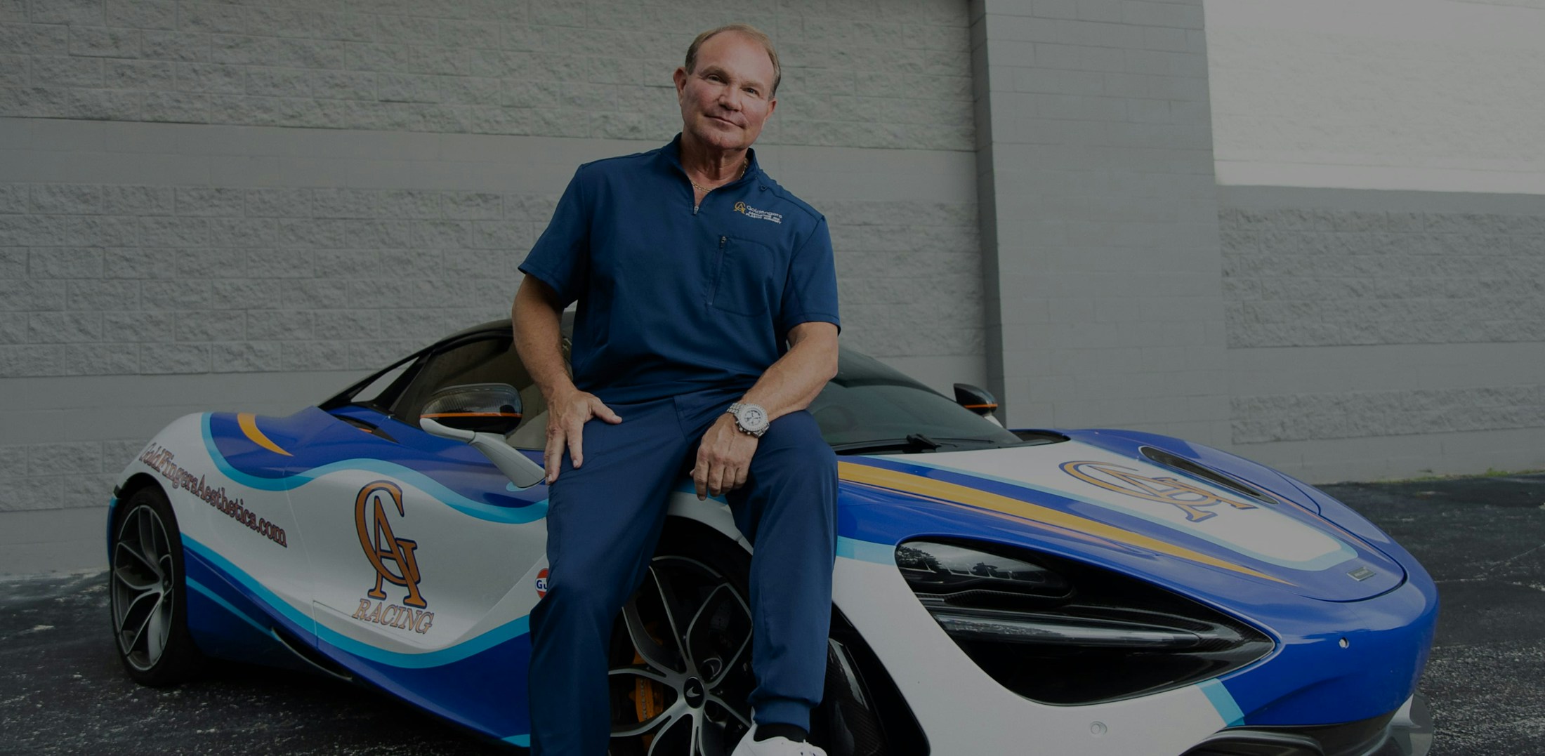 Dr. Young sitting on a sports car