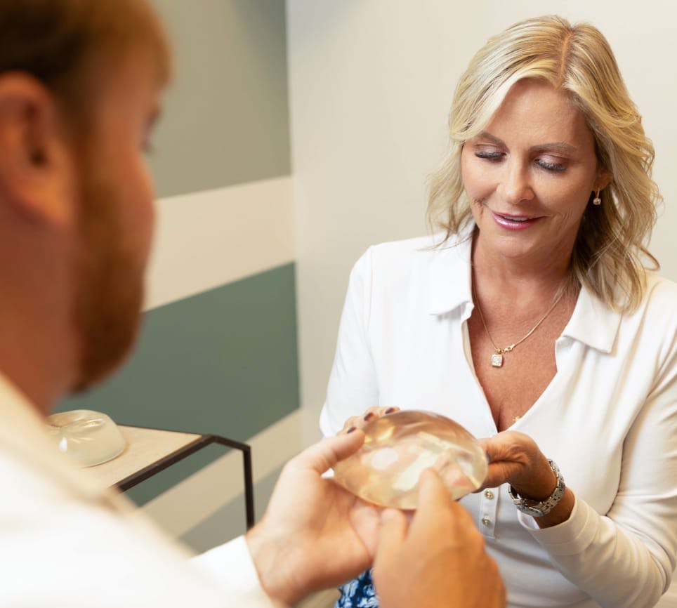 Doctor showing patient breast implant