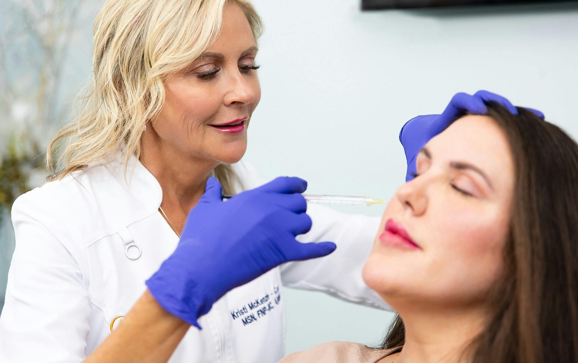 Kristi injecting a patient with filler