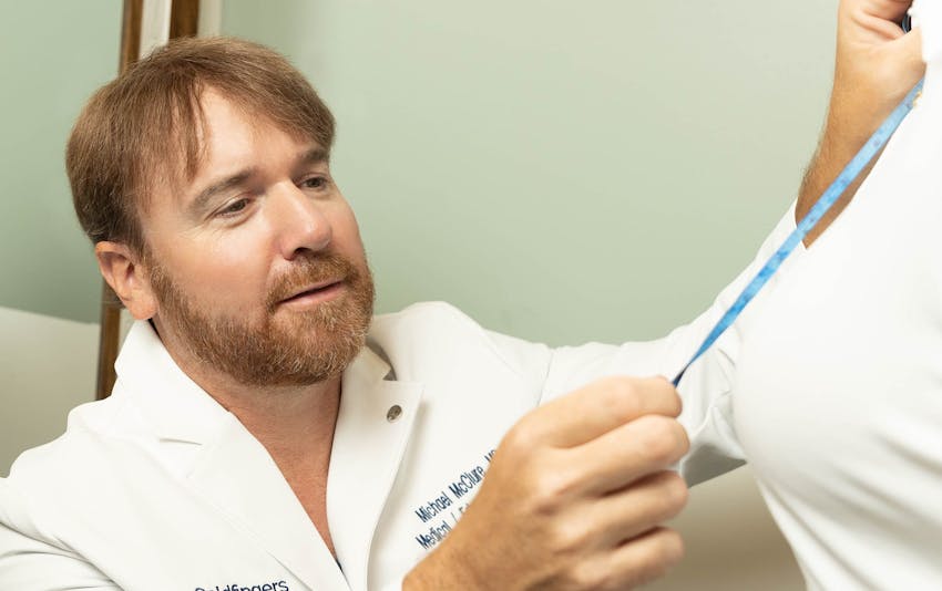 doctor measuring a womans breasts