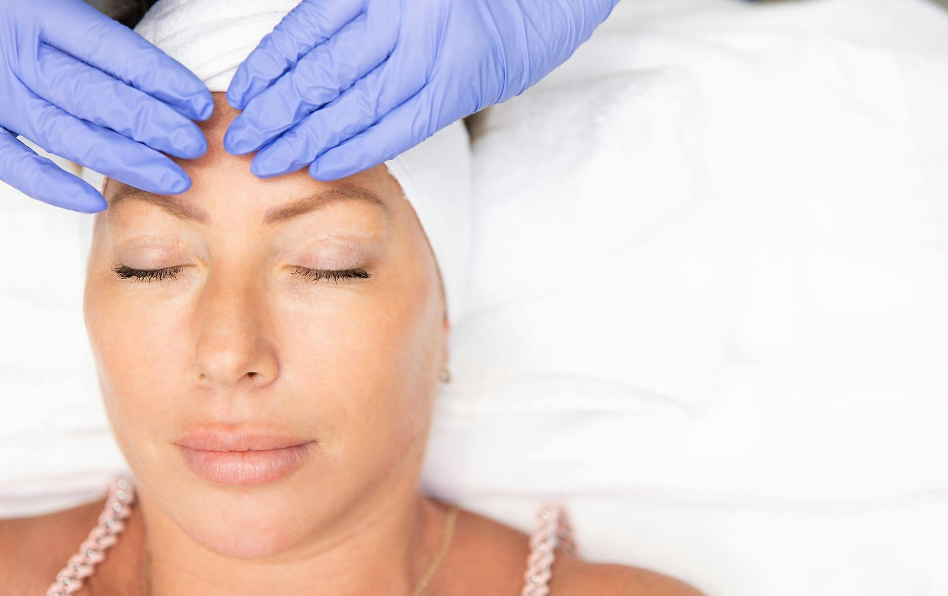 Woman receiving facial treatment