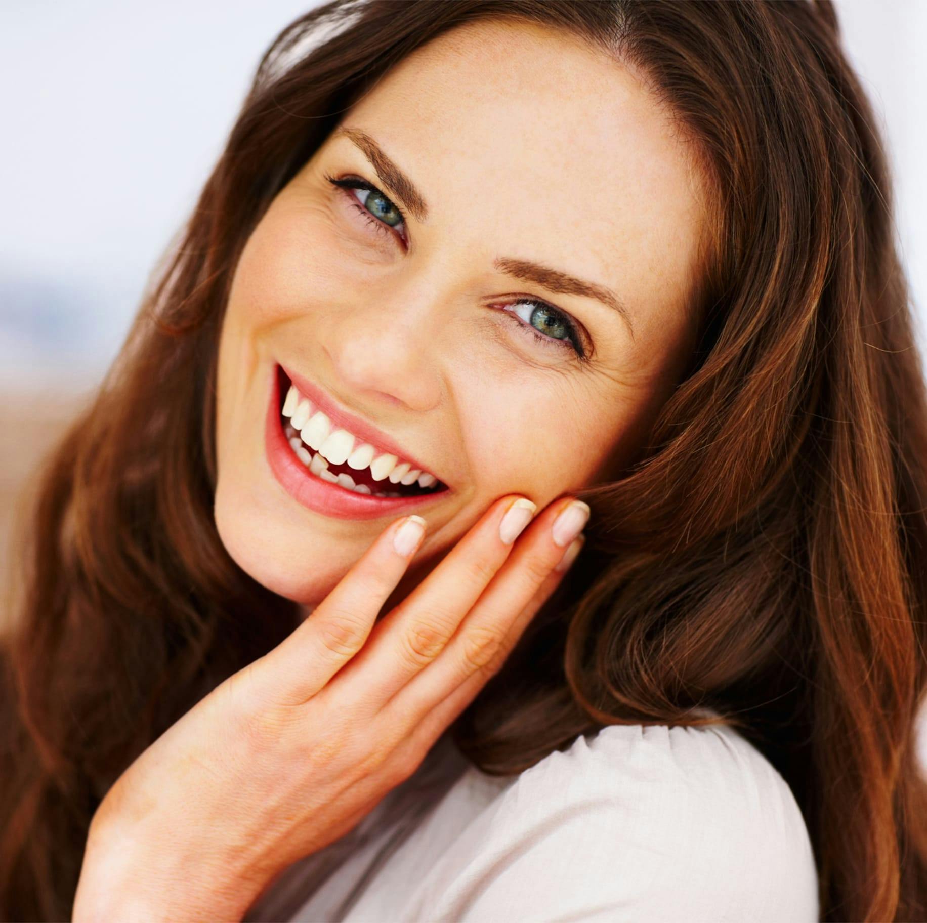 Brunette woman touching face