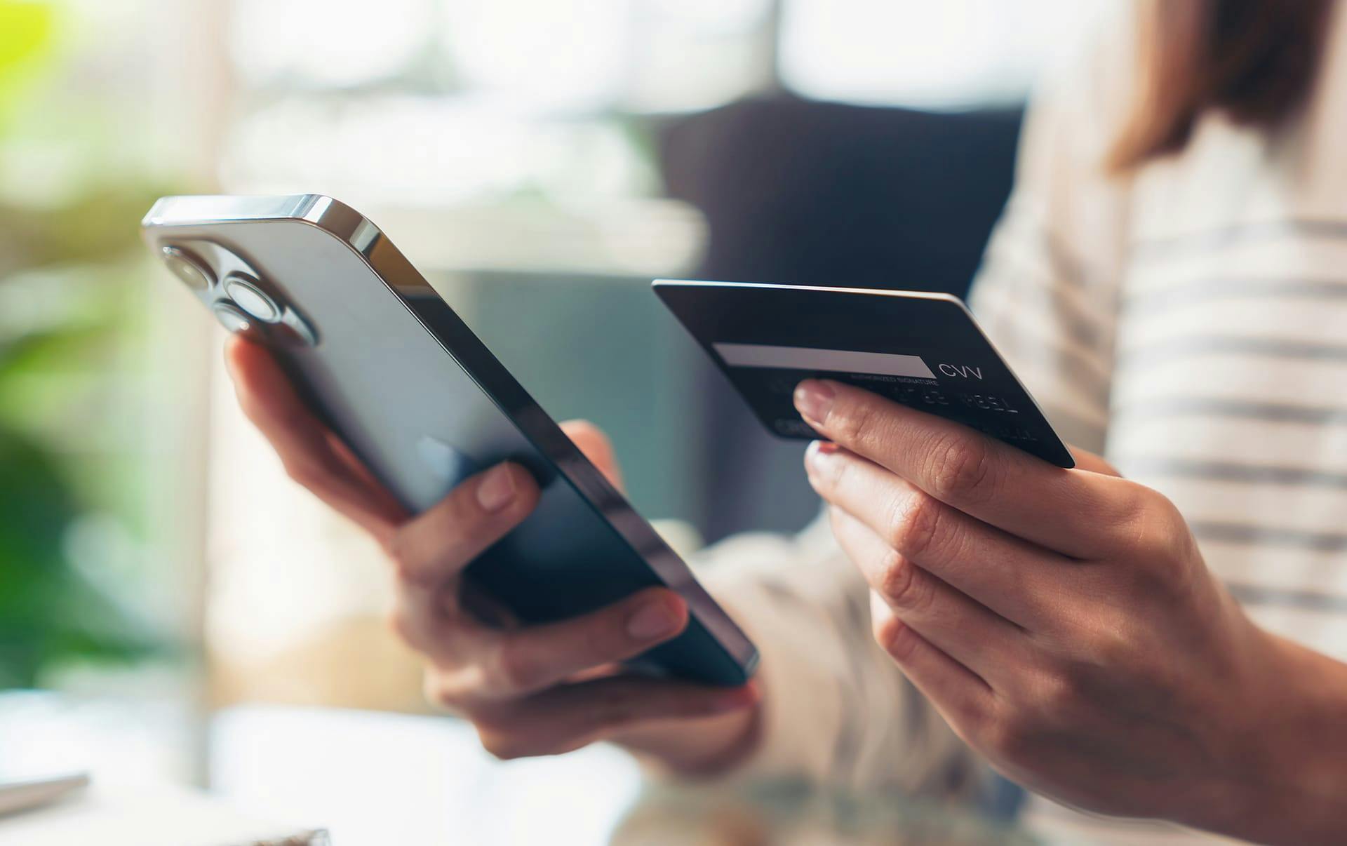 Person entering their credit card information on their cell phone