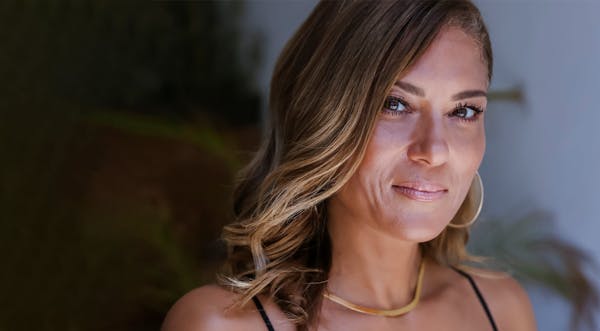Woman with gold necklace, smiling