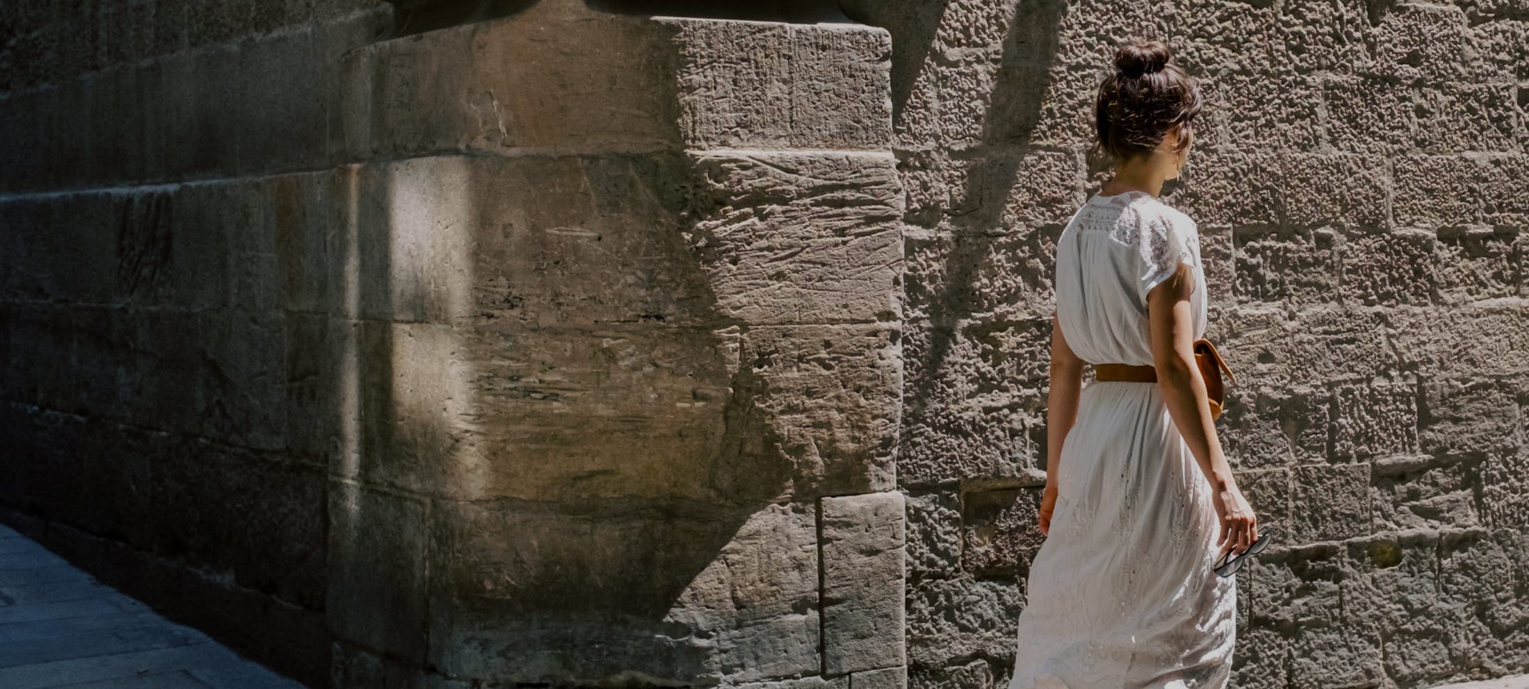 Woman next to stone wall