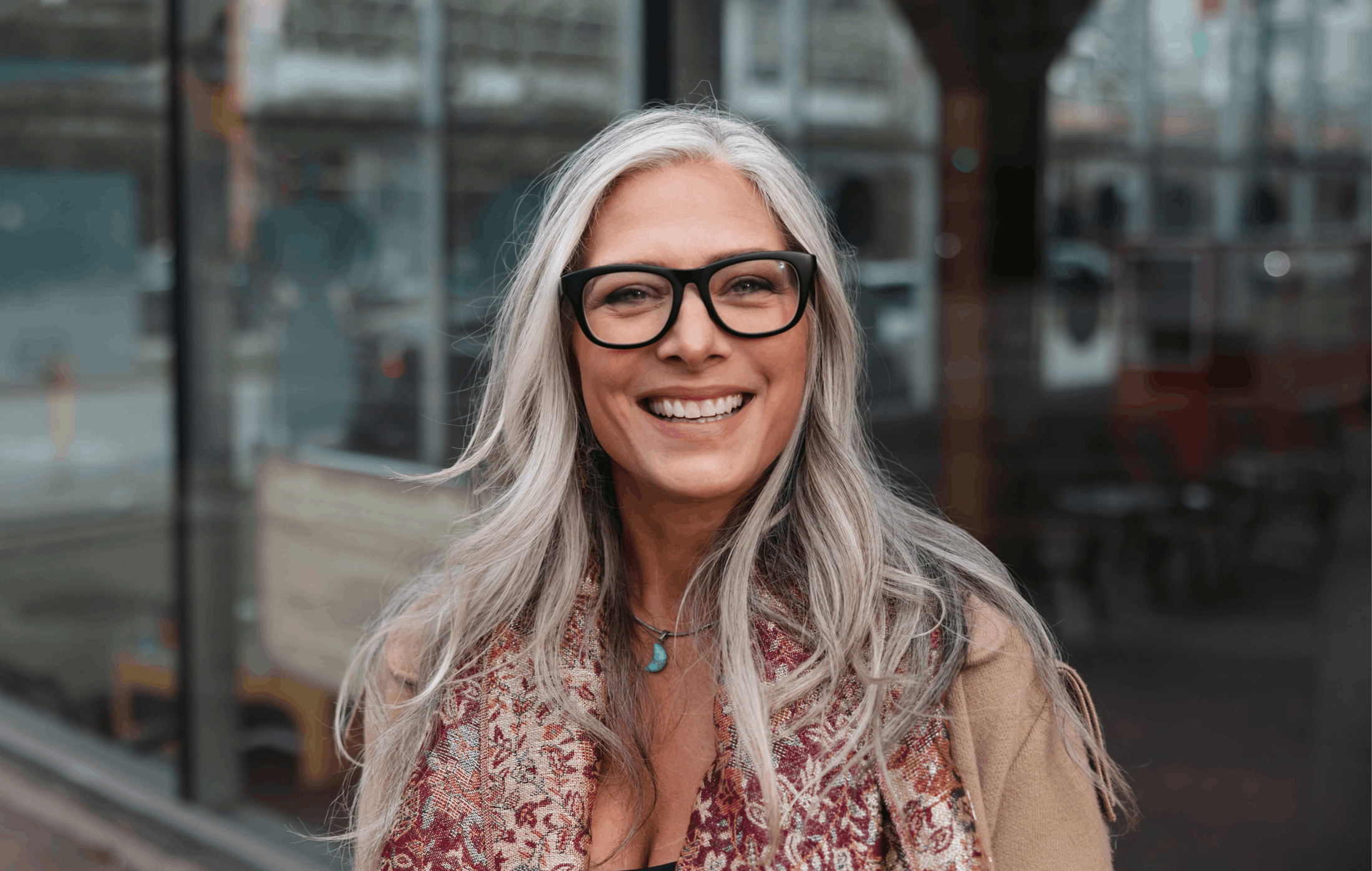 Woman with glasses on the street, smiling