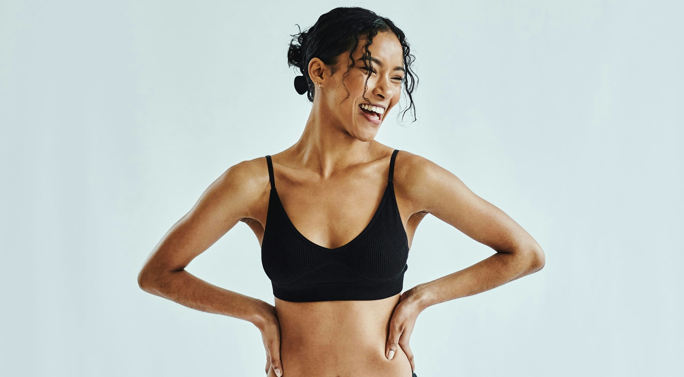 Woman in a sports bra with her arms to her side