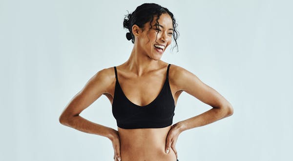 Woman in a sports bra with her arms to her side