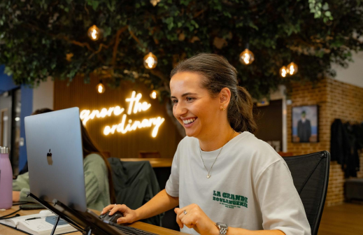 A woman smiling while working at a desk