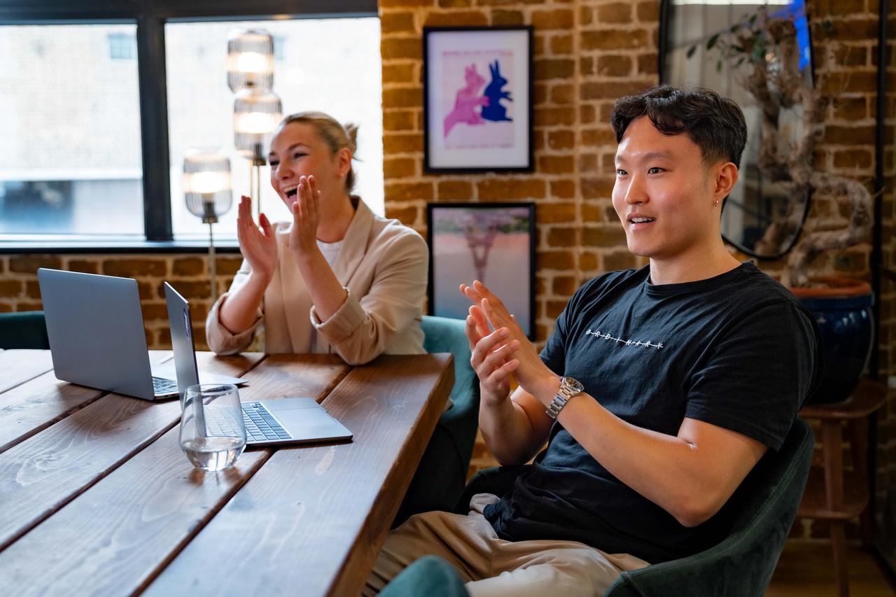 girl and guy clapping in meeting