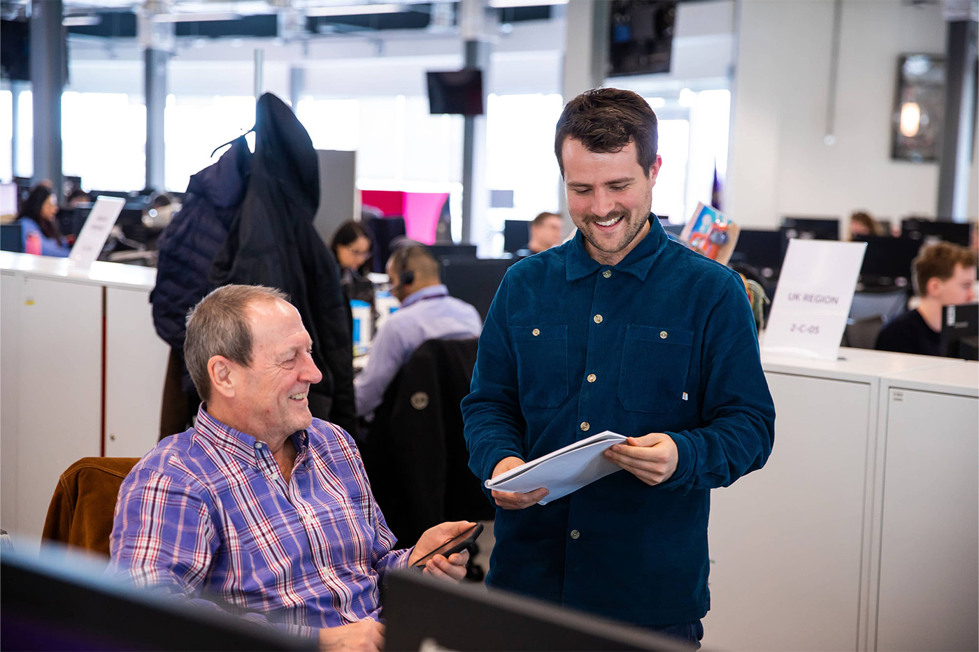 Two men laughing at a desk