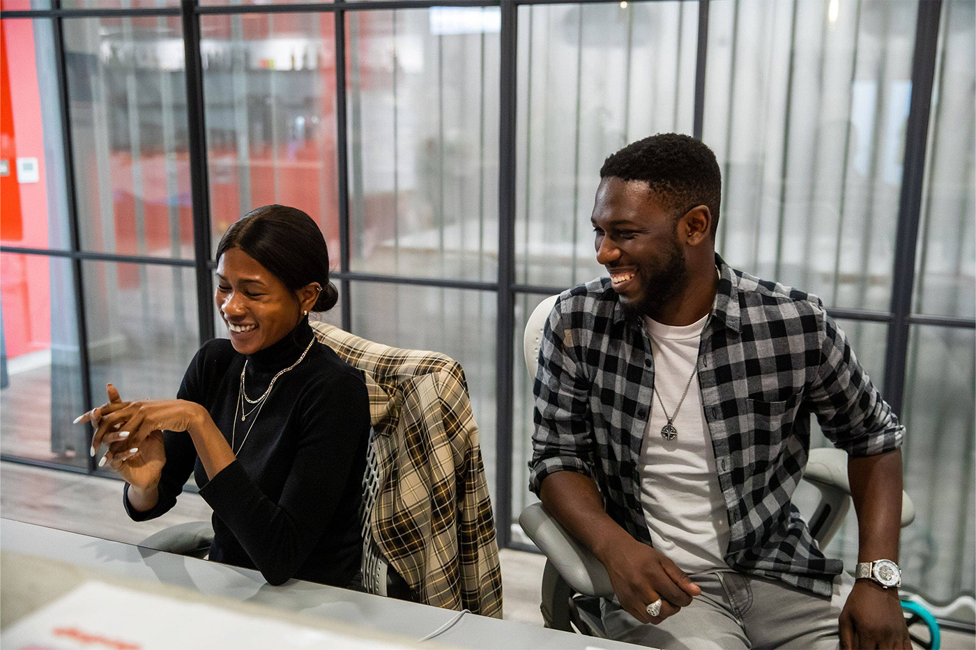 Two colleagues laughing at a desk