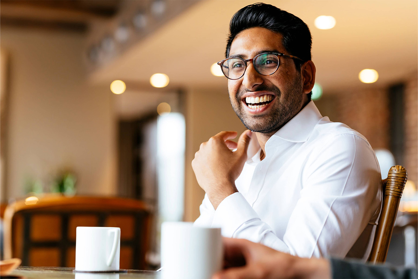Man smiling at work with a coffee